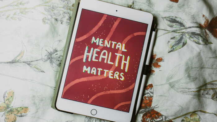 Tablet mit Schriftzug "Mental Health Matters" auf Bett