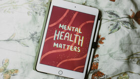 Tablet mit Schriftzug "Mental Health Matters" auf Bett